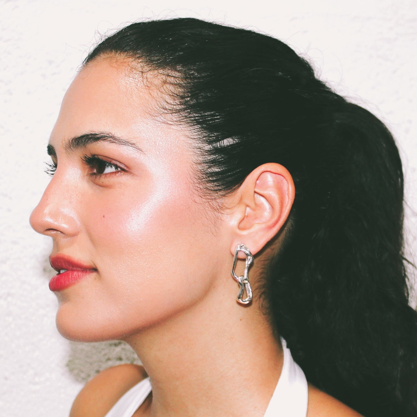 Close-up of a person wearing a silver earring jewellery handmade lisbon