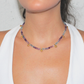 Necklace with multicolored fluorite beads and gold charm worn by a person