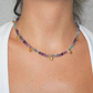 Necklace with multicolored fluorite beads and gold charm worn by a person