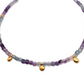 Necklace with multicolored beads fluorite gold charms on a white background