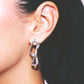Close-up of a person wearing a silver earring jewellery handmade lisbon 