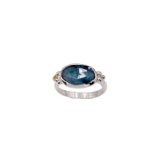 Silver ring with a blue gemstone on a white background