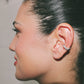 Close-up of a person's ear with an ear cuff against a neutral background jewellery handmade lisbon