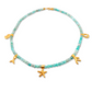Necklace with aquamarine turquoise beads and gold ocean charms on a white background